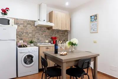 a kitchen with a table and a washer and dryer at QuattroCantiApartment2 Palermo in Palermo