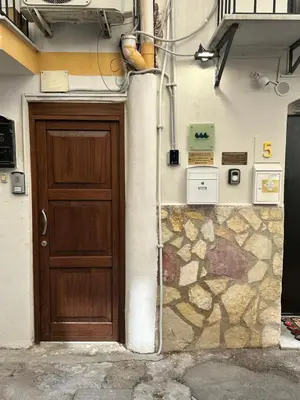 a building with a wooden door and a stone wall at QuattroCantiApartment2 Palermo in Palermo