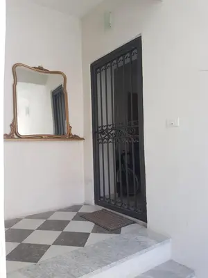 a black door on a white wall with a mirror at Vucciria room in Palermo