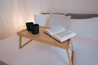 a table with two books and two cups on a bed at Casamusa suite in Palermo