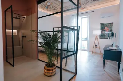 a room with a glass partition with a potted plant at Casamusa suite in Palermo