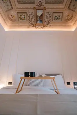 a bed with a wooden table on top of it at Casamusa suite in Palermo