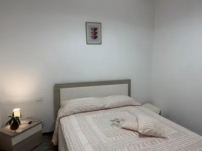 a bedroom with a bed with a white comforter at La Dolcissima in Castellammare del Golfo