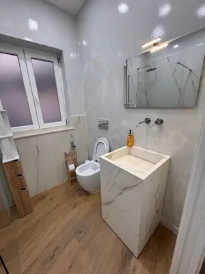 a white bathroom with a sink and a toilet at Domus ad Max- La casa nel cuore di Palermo in Palermo