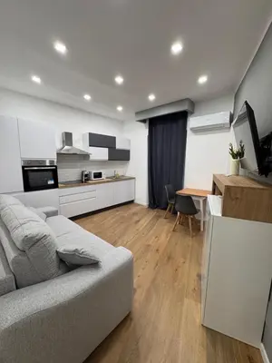 a living room with a couch and a kitchen at Domus ad Max- La casa nel cuore di Palermo in Palermo