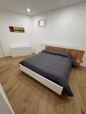 a large bed in a room with a wooden floor at Domus ad Max- La casa nel cuore di Palermo in Palermo