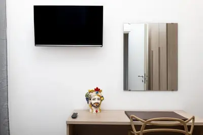 a room with a table with a mirror and a vase at 105 Apartments in Palermo