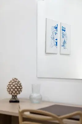 a table with a chair and two pictures on the wall at 105 Apartments in Palermo