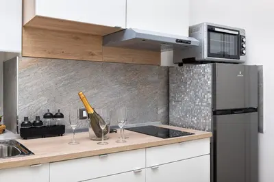 a kitchen with a counter with wine glasses and a microwave at 105 Apartments in Palermo