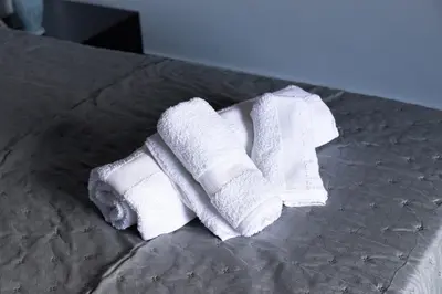 two rolls of white towels sitting on a bed at Cuor di Leone in Corleone