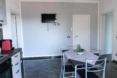 a kitchen with a table with chairs and a tv on the wall at Cuor di Leone in Corleone