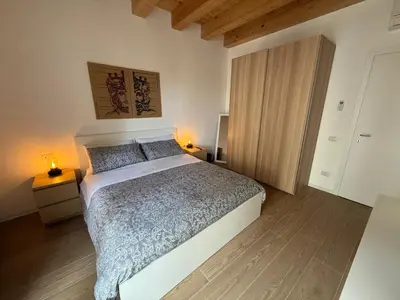 a bedroom with a large bed and a wooden floor at La Cala Holiday Flat in Palermo