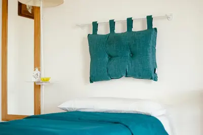 a bed with blue and white pillows on a wall at Villa Torre Ulisse Locazione Turistica Affitti Brevi in Carini