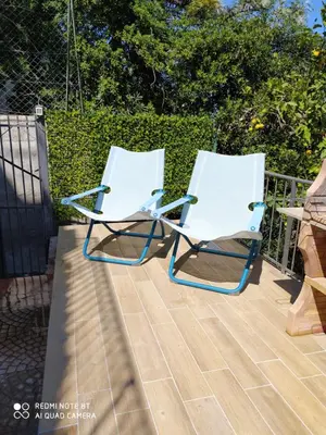 two white chairs sitting on a deck at Capozafferano-Casa Carola in Santa Flavia