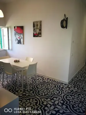 a dining room with a white table and chairs at Capozafferano-Casa Carola in Santa Flavia