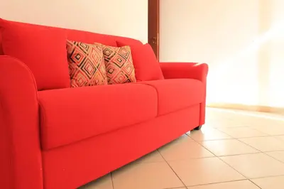 a red couch with two pillows on it in a room at Ville Tiffany in Campofelice di Roccella