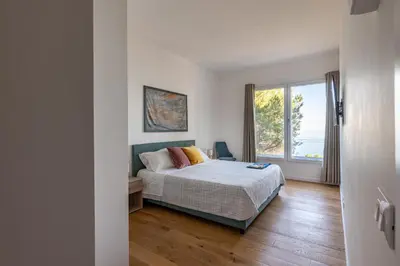 a bedroom with a bed and a large window at Villa con accesso al mare e vista mozzafiato in Palermo