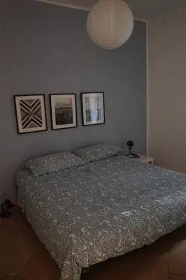 a bedroom with a bed with three pictures on the wall at La Casetta al Mercato del Capo in Palermo
