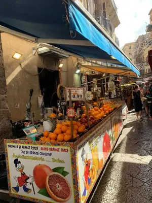 a fruit stand with oranges on display in a street at La Casetta al Mercato del Capo in Palermo