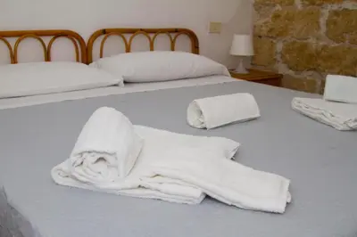 a bed with two white towels on it at Terrasini 2000 Casa Vacanze in Terrasini