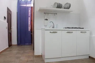 a kitchen with white cabinets and a sink at Terrasini 2000 Casa Vacanze in Terrasini