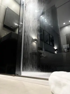 a bathroom with a shower with a waterfall at Santa Rosalia Suites in Palermo