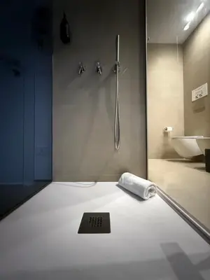 a bathroom with a shower with a scale on the floor at Santa Rosalia Suites in Palermo
