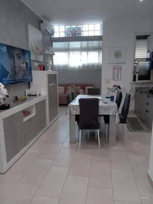 a kitchen and living room with a table and chairs at Dolce casa in Palermo