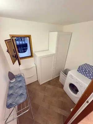 a laundry room with a washing machine and a chair at Nova Holidays in Palermo
