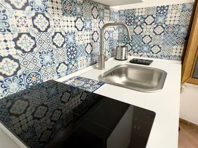 a kitchen with a sink and blue and white tiles at Nova Holidays in Palermo