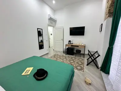 a room with a bed with a hat on it at Kàlia Rooms in Palermo