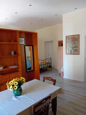 a dining room table with a vase of flowers on it at Vernagallo's House 2 in Palermo