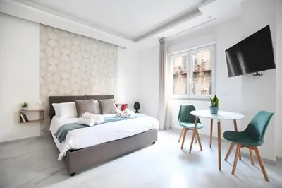 a bedroom with a bed and a table and chairs at iFlat Casa Diamante in Palermo