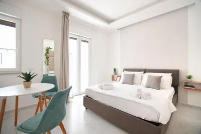 a white bedroom with a bed and a table and chairs at iFlat Casa Diamante in Palermo
