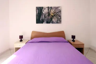 a bedroom with a purple bed with two night stands at Pompei in Castellammare del Golfo