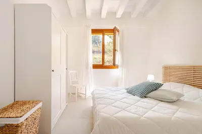 a white bedroom with a bed and a window at Villa Four by Sicily Travelling Villas in Scopello
