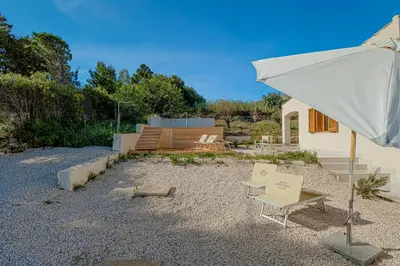 a patio with an umbrella and a table and chairs at Villa Four by Sicily Travelling Villas in Scopello
