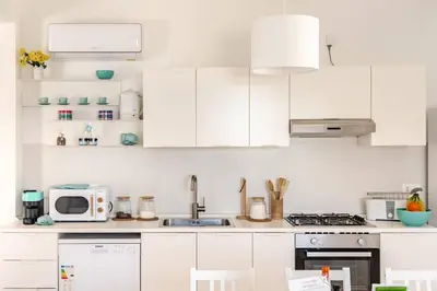 a white kitchen with white cabinets and appliances at Villa Four by Sicily Travelling Villas in Scopello
