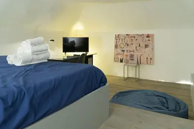 a bedroom with a bed and a tv and towels at La Terza Porta in Palermo