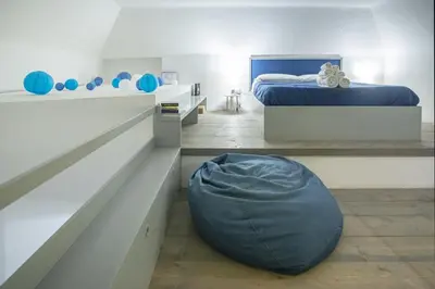 a bedroom with a bed and a bean bag chair at La Terza Porta in Palermo
