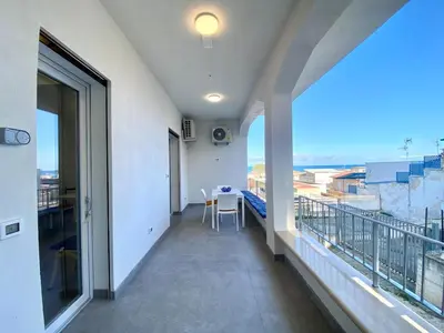 a balcony with a table and views of a city at Casa La Mamà, a 150 mt dal mare in Alcamo
