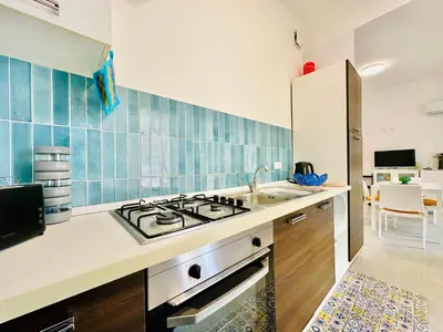 a kitchen with a sink and a stove top oven at Casa La Mamà, a 150 mt dal mare in Alcamo