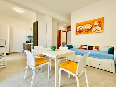 a room with a table and chairs and a bed at Casa La Mamà, a 150 mt dal mare in Alcamo
