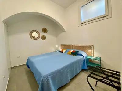 a bedroom with a blue bed and a window at Casa La Mamà, a 150 mt dal mare in Alcamo
