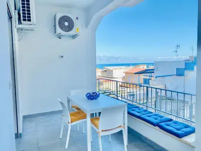 a white table and chairs on a balcony at Casa La Mamà, a 150 mt dal mare in Alcamo