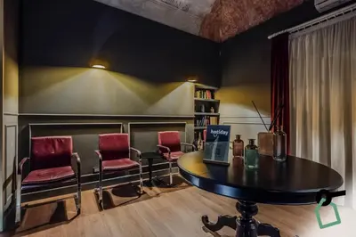 a waiting room with a table and two chairs at HOTIDAY Palermo Palco Noir in Palermo