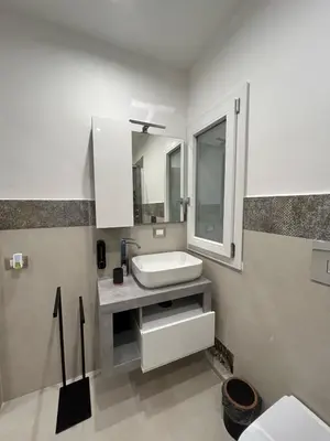 a white bathroom with a sink and a mirror at Le Piccole Duse in Palermo