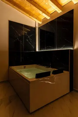 a bath tub in a room with black tiles at Le Piccole Duse in Palermo