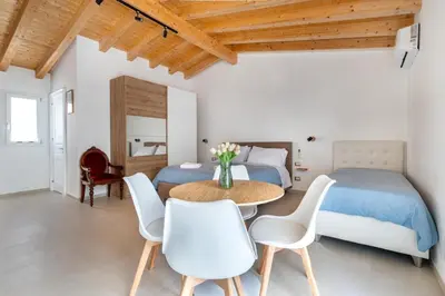 a bedroom with two beds and a table and chairs at Le Piccole Duse in Palermo