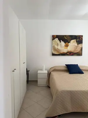a bedroom with a bed and a painting on the wall at Soraya House Next quattrocanti in Palermo